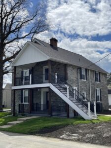 deck and stair builder services on a grey cobblestone house