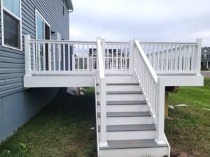 small deck build grey wood and white railings