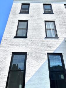 white siding building with black windows