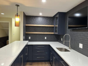 A kitchen with white counters and black cabinets