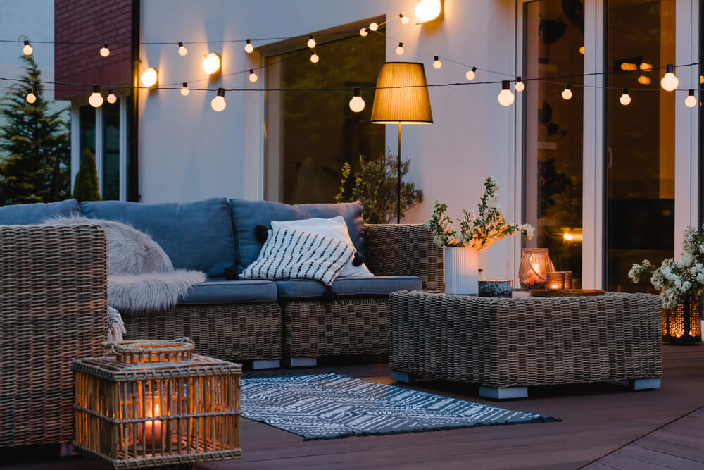 String lights hung up over comfortable outdoor furniture