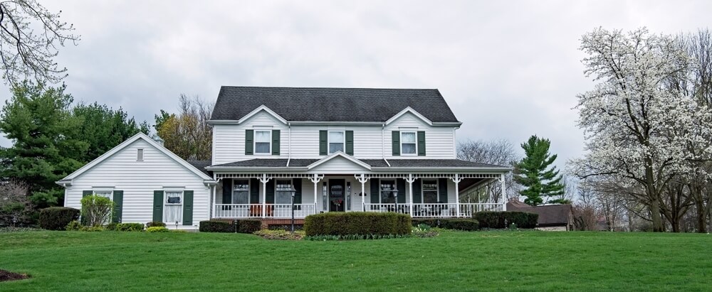 A large white house with an added in-law suite on the side.