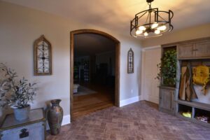 Foyer remodel with a herringbone tile floor and an arched doorway