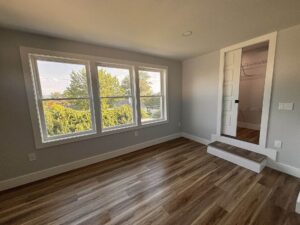 Home remodel with wooden floors and three windows along the wall
