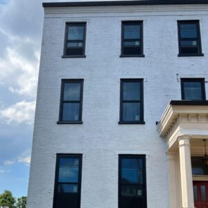 Wiindows with black trim on white brick siding