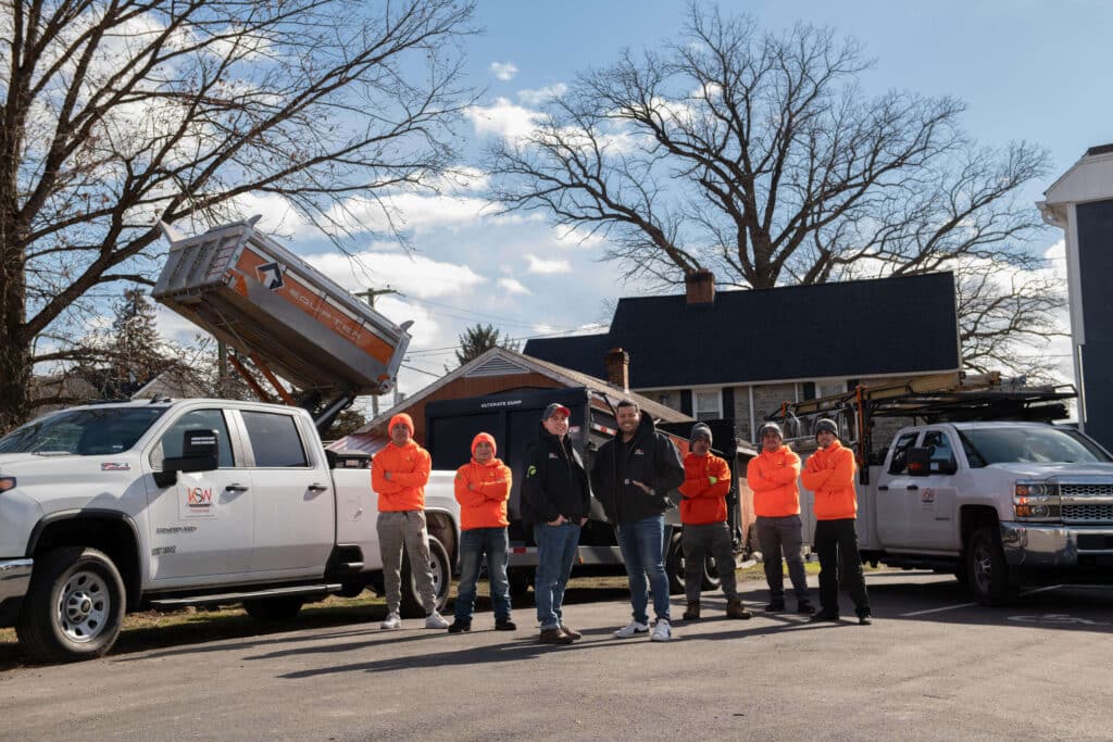 general contractor in Montgomery County, PA team standing on front of two trucks and a house