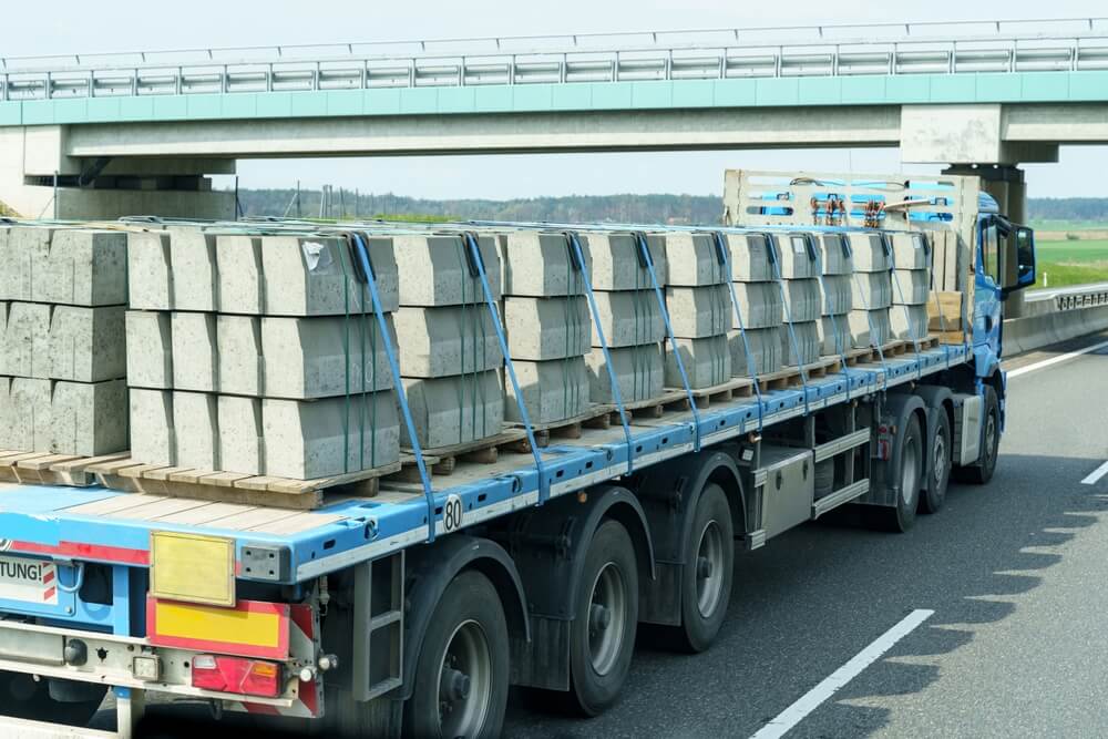 A truck transports building materials on the highway